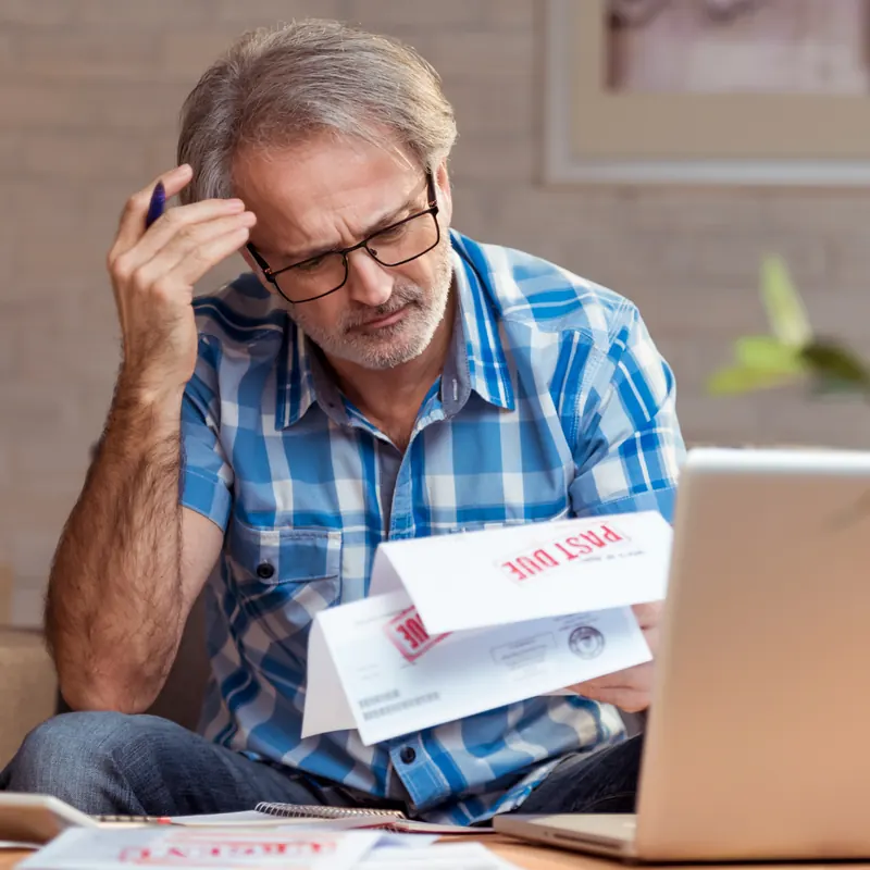 Worried homeowner reviewing a past due mortgage notice